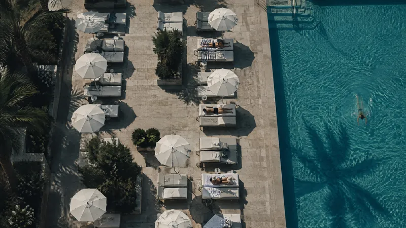 Poolside loungers and white parasols seen from above