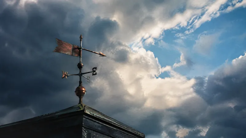 Weather vane against a sky of heavy cloud